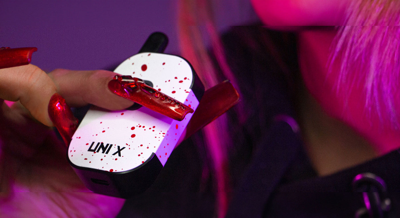 woman with red long nails holding the Wulf UNI X inside studio with red lighting